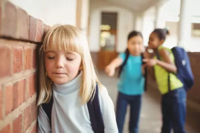 44851407 - sad pupil being bullied by classmates at corridor in school